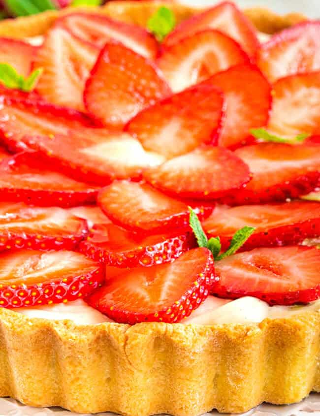 A close up image of a tart decorated with sliced strawberries.