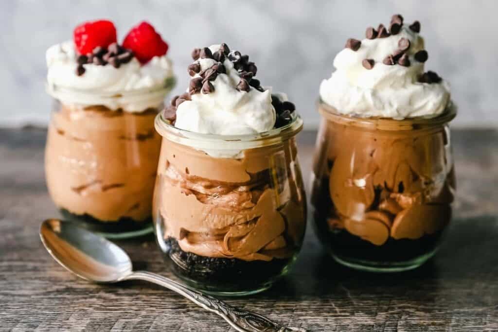 Three dessert glasses filled with Chocolate Nutella Cheesecake Mousse. 