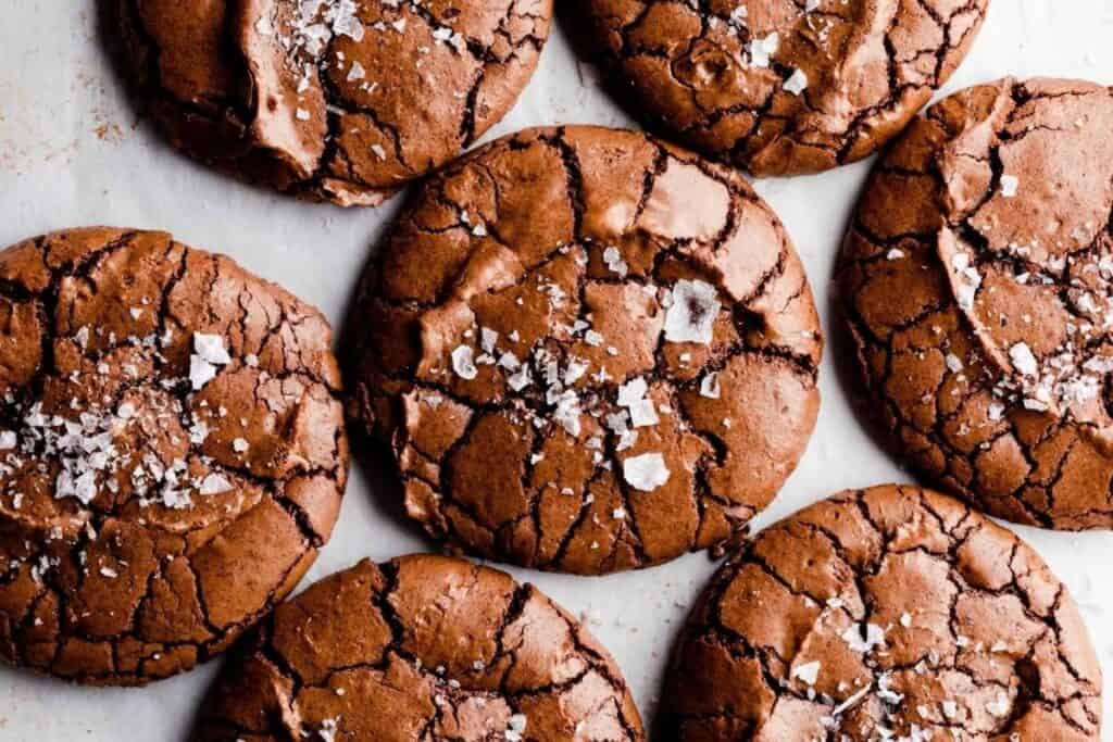 A close up image of Chocolate Brownie Cookies  topped with flakes of salt.