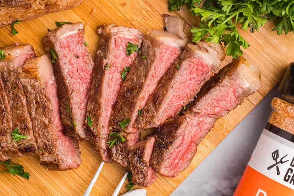 Blackstone Steak sliced on a cutting board.