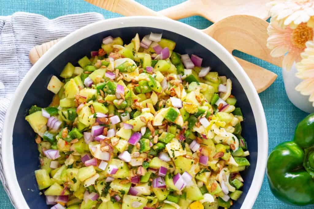 A colorful chopped salad in a white bowl.