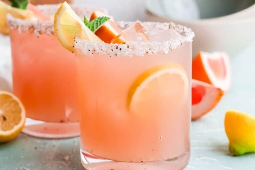 Two Grapefruit Paloma Cocktails with salt on the rims of the glasses.