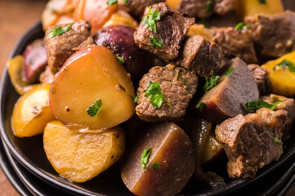 A plat of cubed Garlic Butter Steak Bites And Potatoes.