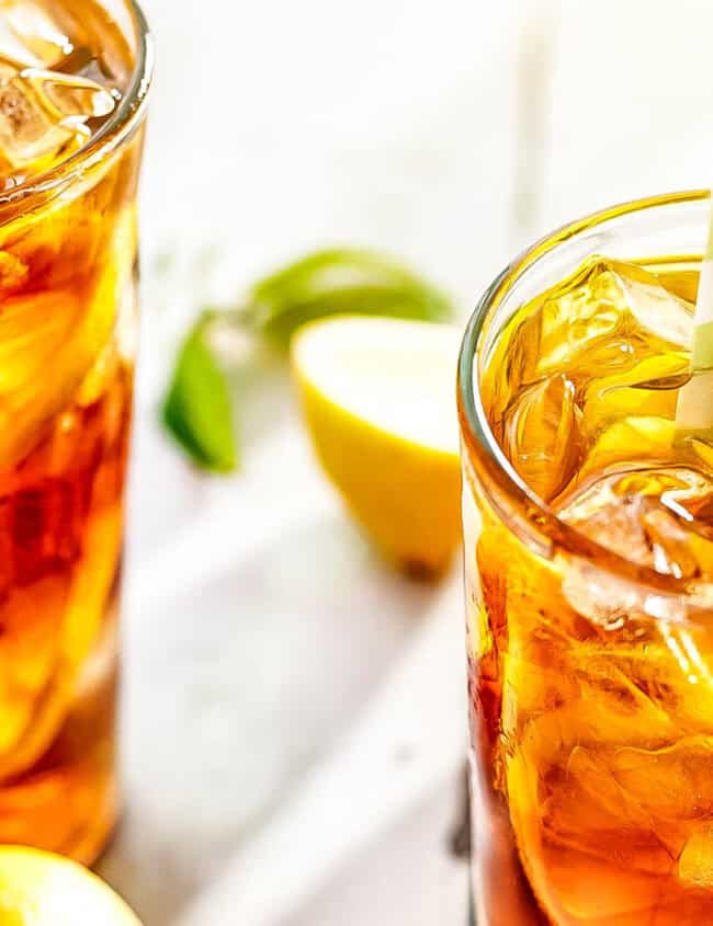 Two glasses of Sweet Lemon Iced Tea with glass and colorful straw in the glasses.