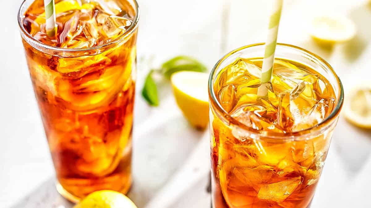 Two glasses of Sweet Lemon Iced Tea with glass and colorful straw in the glasses.