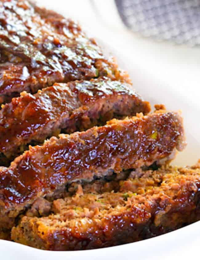 A sliced meatloaf on a serving dish.