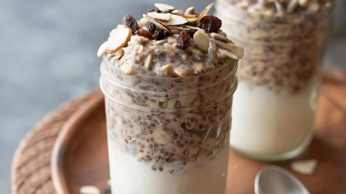 Pumpkin Spice Overnight Oatmeal Parfait in a glass topped with nuts.