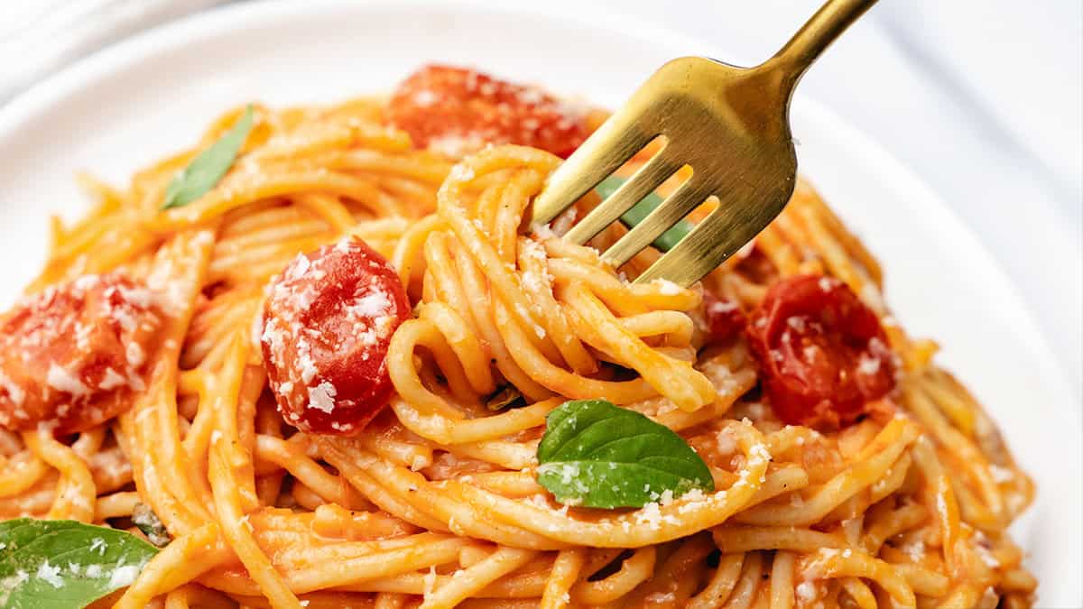 A close up image of a fork twirling spaghetti with Cherry Tomato Sauce.