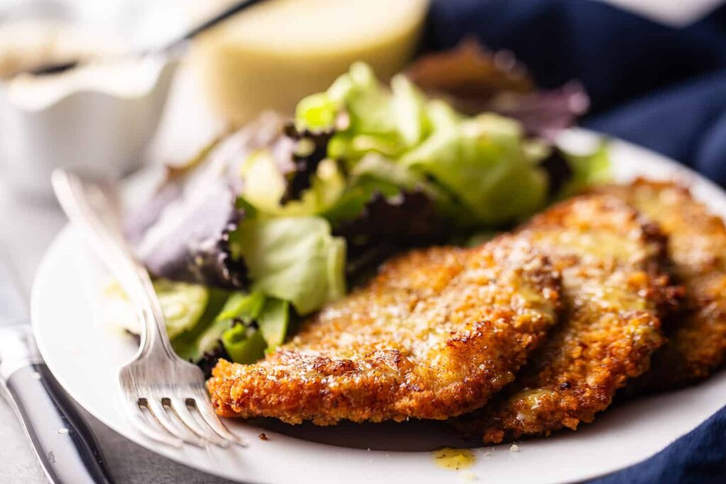 Crispy pork chops on a plate with salad.