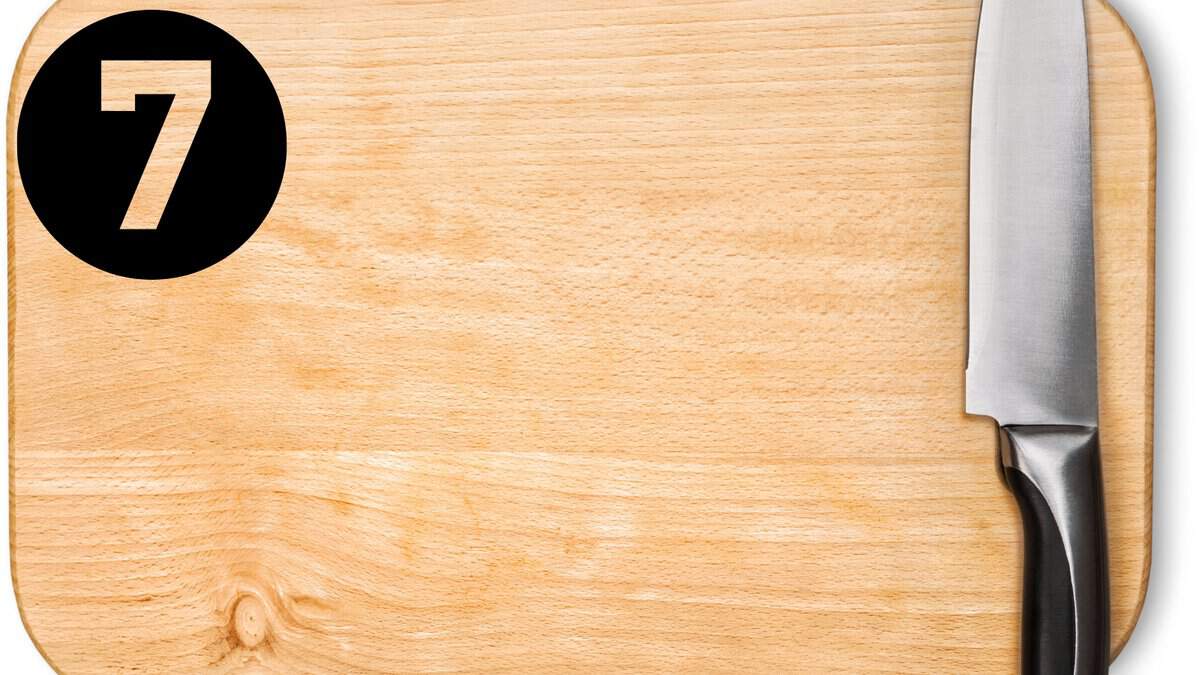 A cutting board with a knife sitting on top of it.