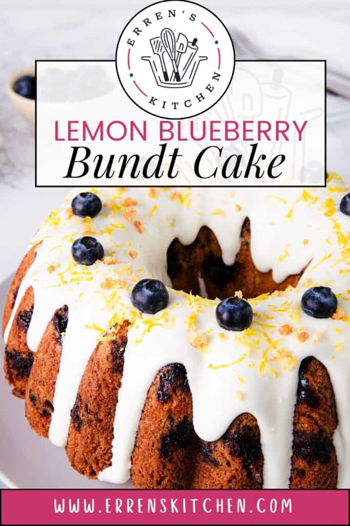 Close-up of a whole Lemon Blueberry Bundt Cake from Erren's Kitchen, featuring a golden brown cake with blueberries visible throughout, topped with a white glaze, fresh blueberries, and lemon zest. The cake is displayed on a white plate with a background showing a bowl of blueberries. Text overlay reads 'Lemon Blueberry Bundt Cake' and 'www.errenskitchen.com.'