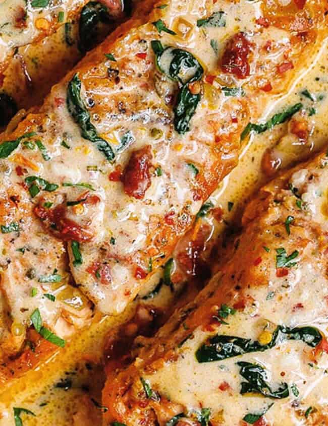 A close up image of Tuscan Salmon in Cream Sauce in a black pan.