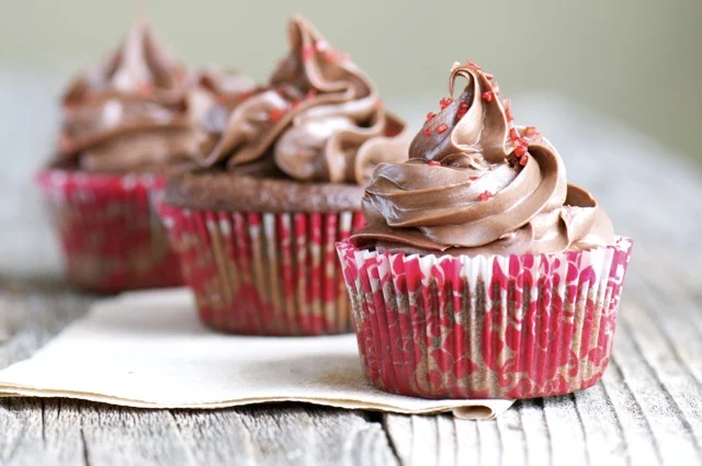 Three Chocolate Cherry Cupcakes topped with swirls of frosting.