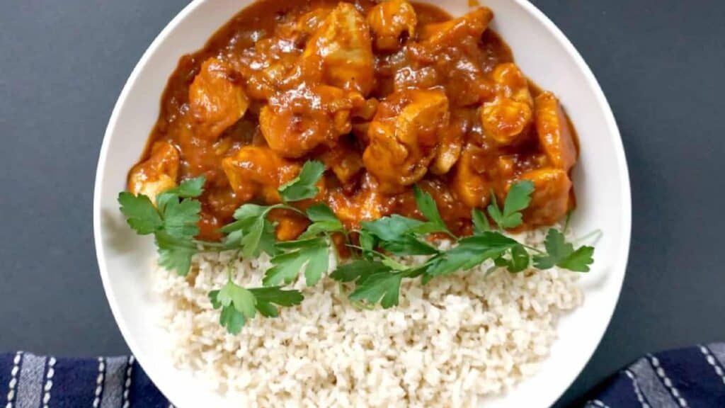 Chicken Curry in a bowl with herbs and rice.