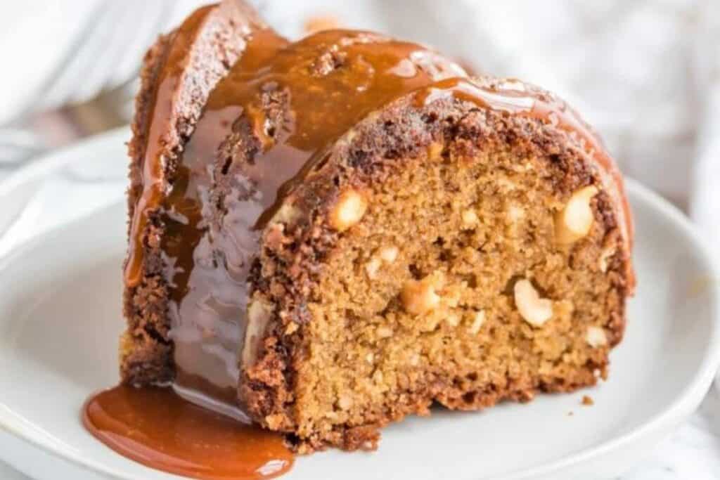 A close up image of a Caramel Nut Bundt Cake with caramel running off of it.