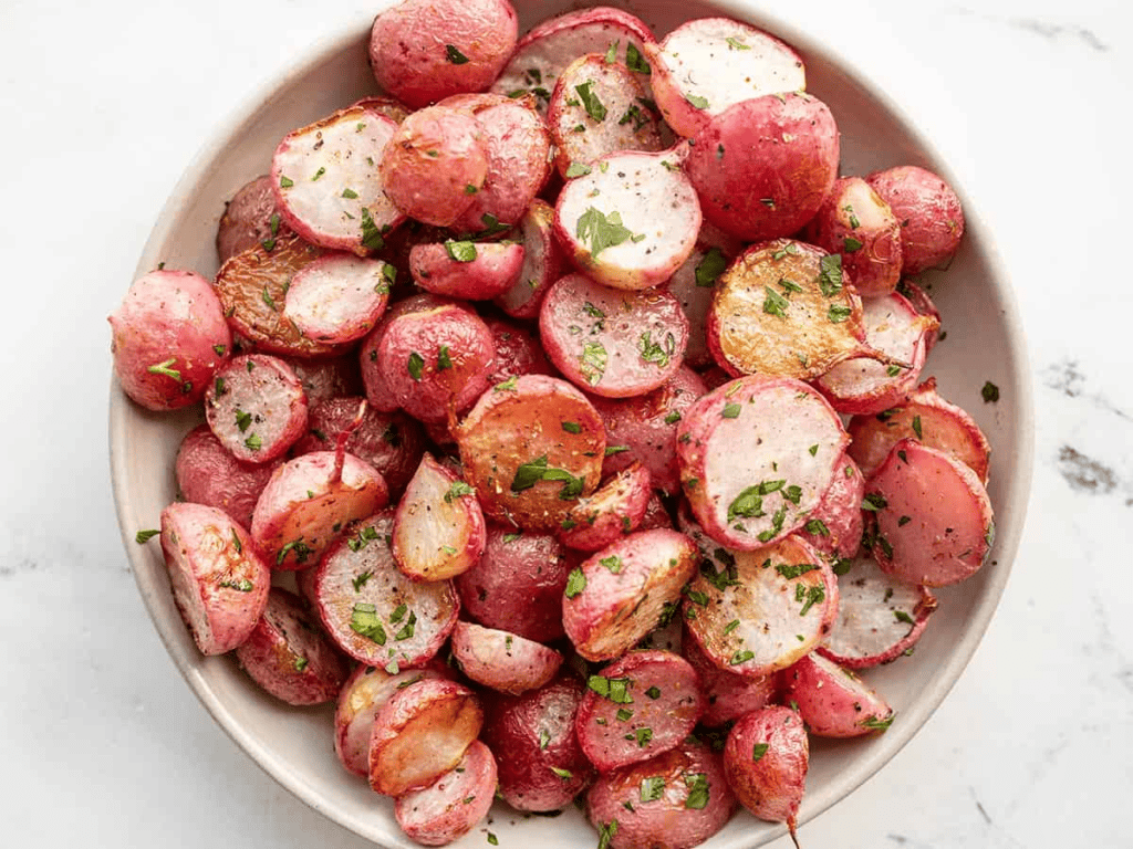 A platter of freshly Roasted radishes garnished with fresh herbs.