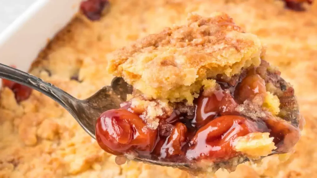 A close up image of a spoonful of Cherry Cobbler.