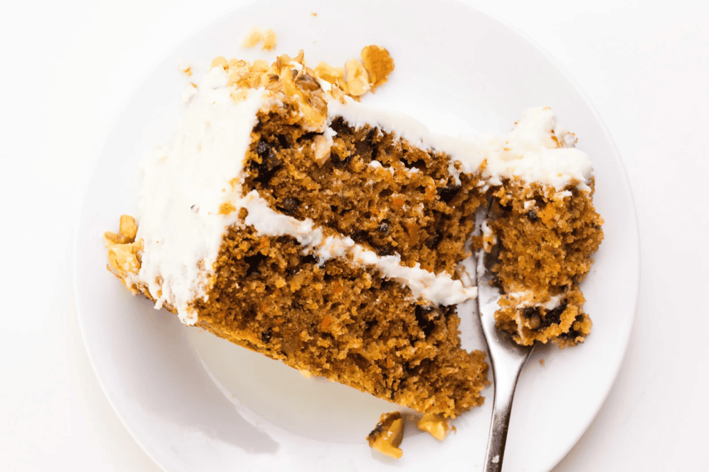 A slice of  vibrant Vegan Carrot Cake on a plate.