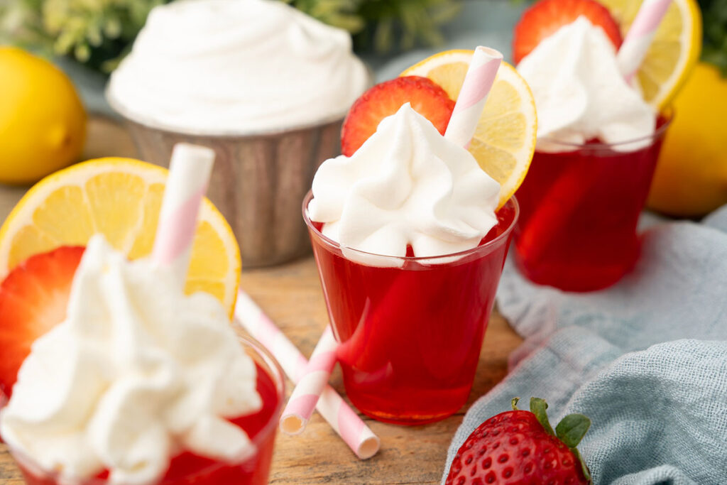 Strawberry Lemonade Vodka Jello Shots. topped with whipped cream.