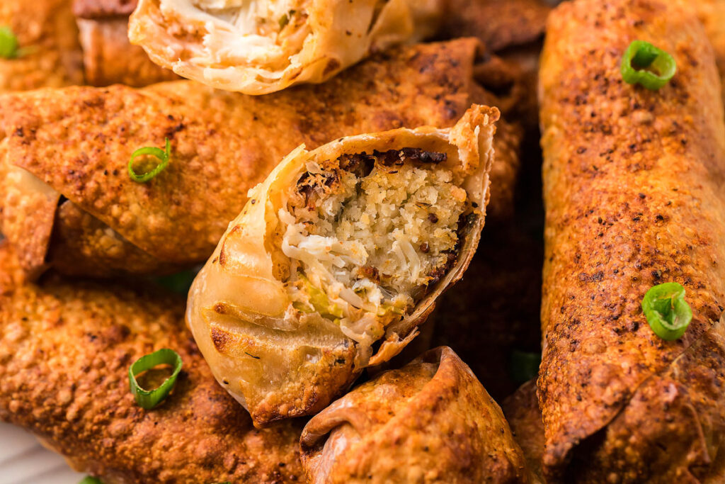 A close up image of a platter of Crab Cake Egg Rolls with one cut open to show the filling.