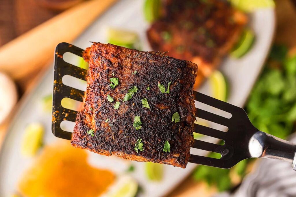 A close up image of a spatula with Blackened Mahi Mahi. 