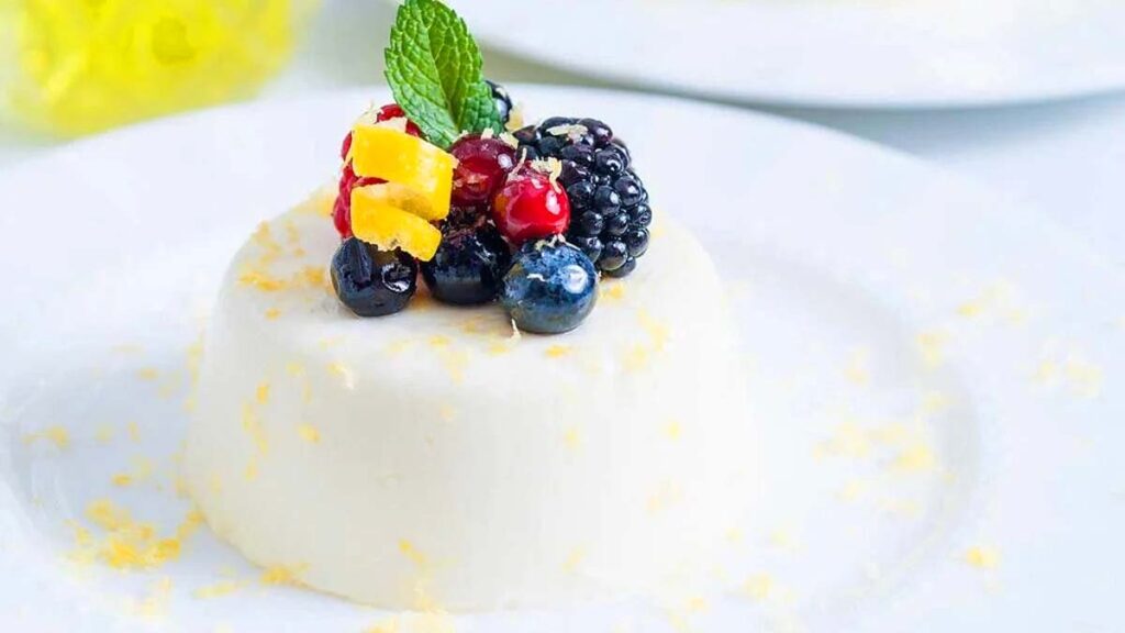 A close up image of Limoncello Panna Cotta topped with berries.