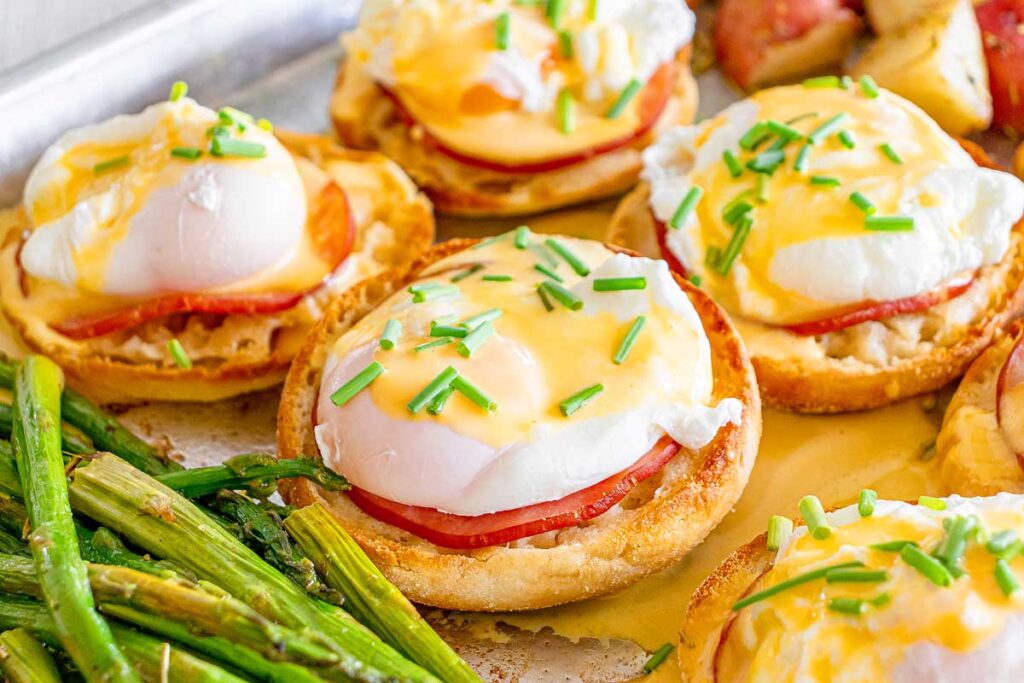 Eggs Benedict. on a sheet pan with asparagus.