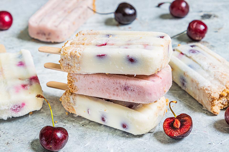 Three stacked Cherry Cheesecake Popsicles. 