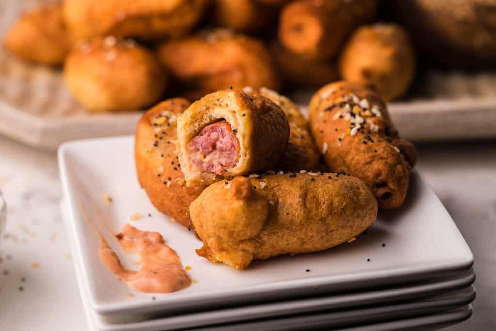 A close up image of Everything Bagel Beer Dogs.  on a white plate.