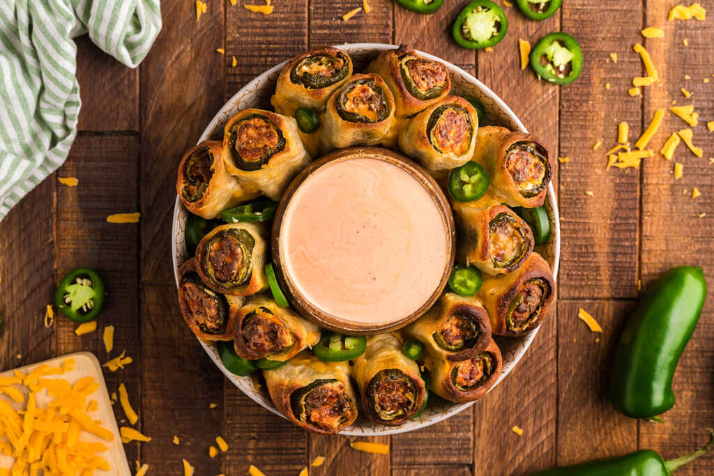 Pull Apart Jalapeño Popper Rolls on a platter with a dipping sauce.