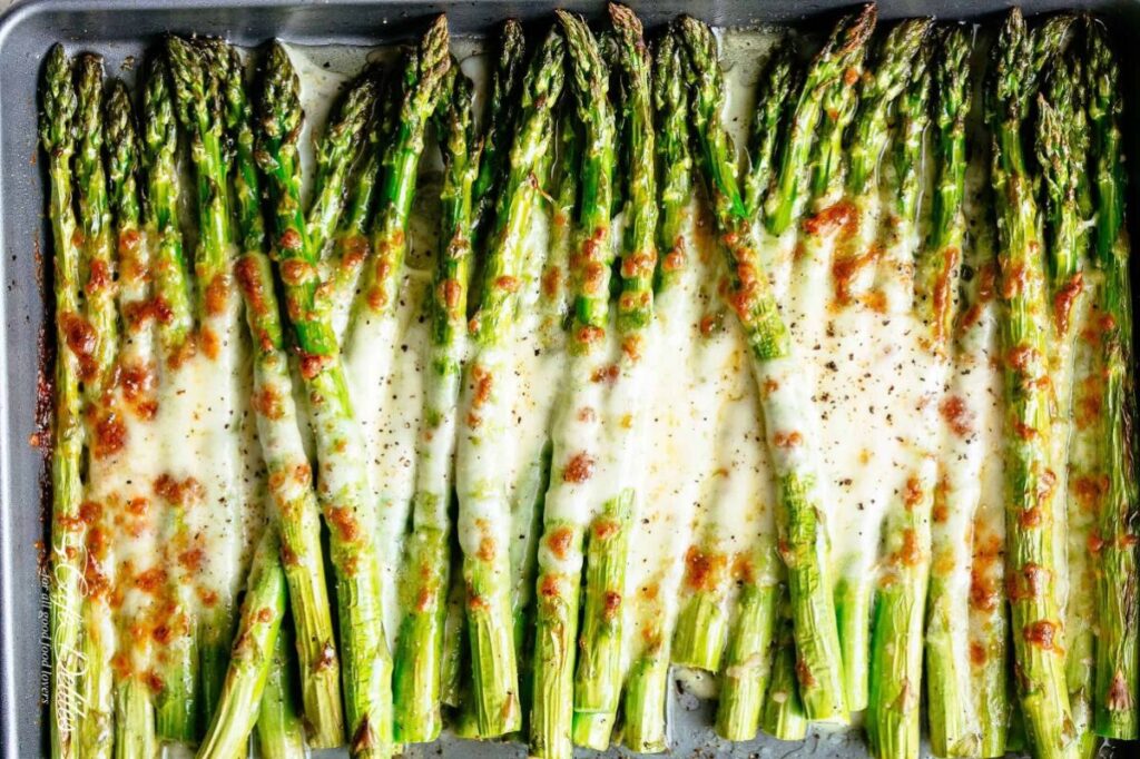 A close up image of a platter of Cheesy Garlic Roasted Asparagus. 