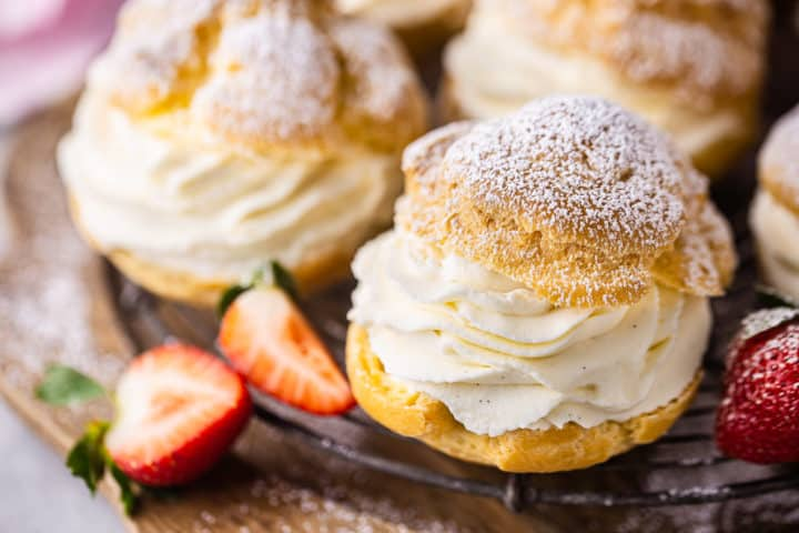 A close up image of cream puffs on a plate.