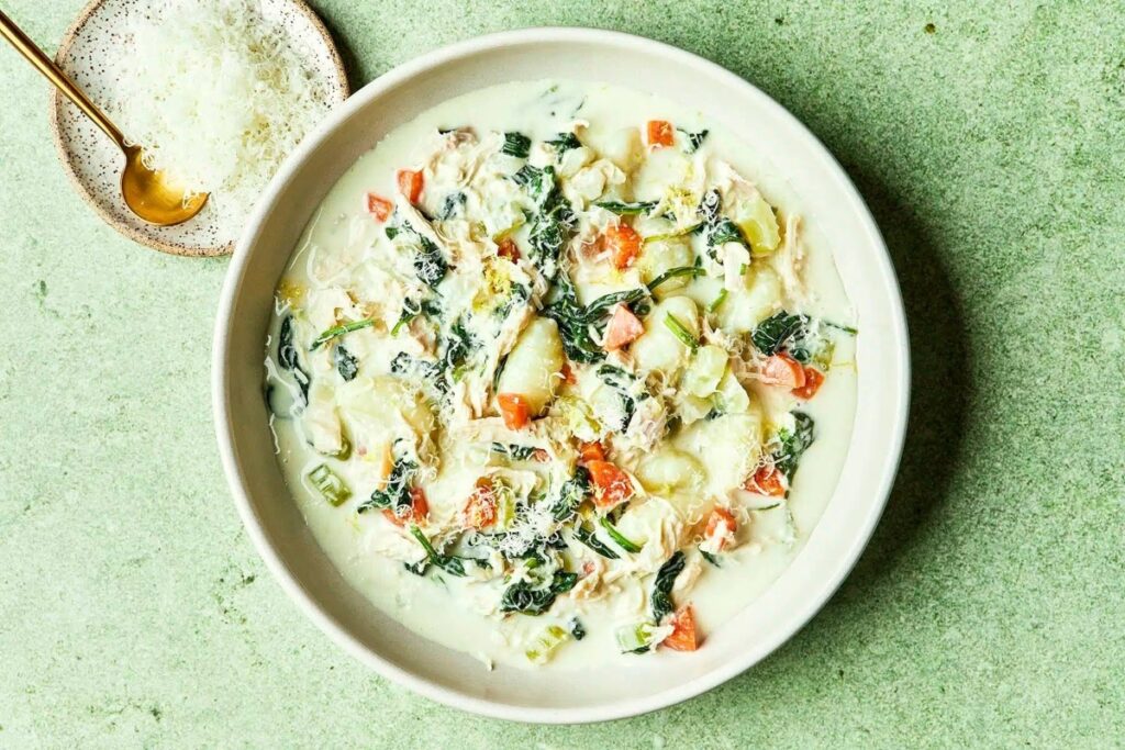 An overhead image of a white bowl Chicken Florentine Soup. 