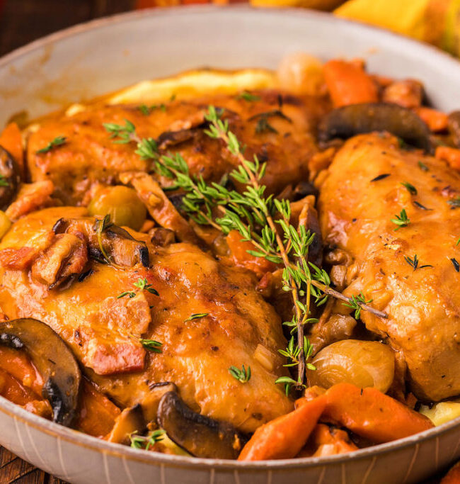 A close up image of a bowl of Chicken Braised in Red Wine.