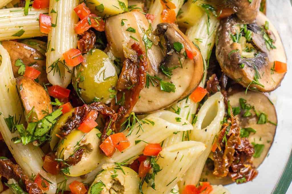 A close up image of Marinated Mushroom Pasta Salad With Green Olives. 