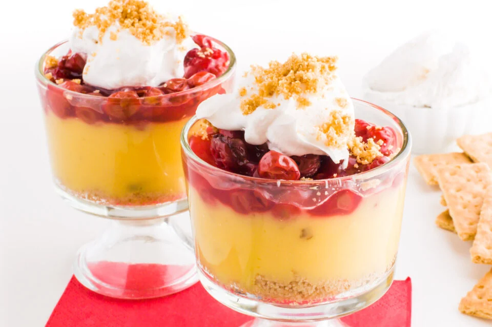 Two glasses of layered Vegan Cherry Vanilla Parfaits.