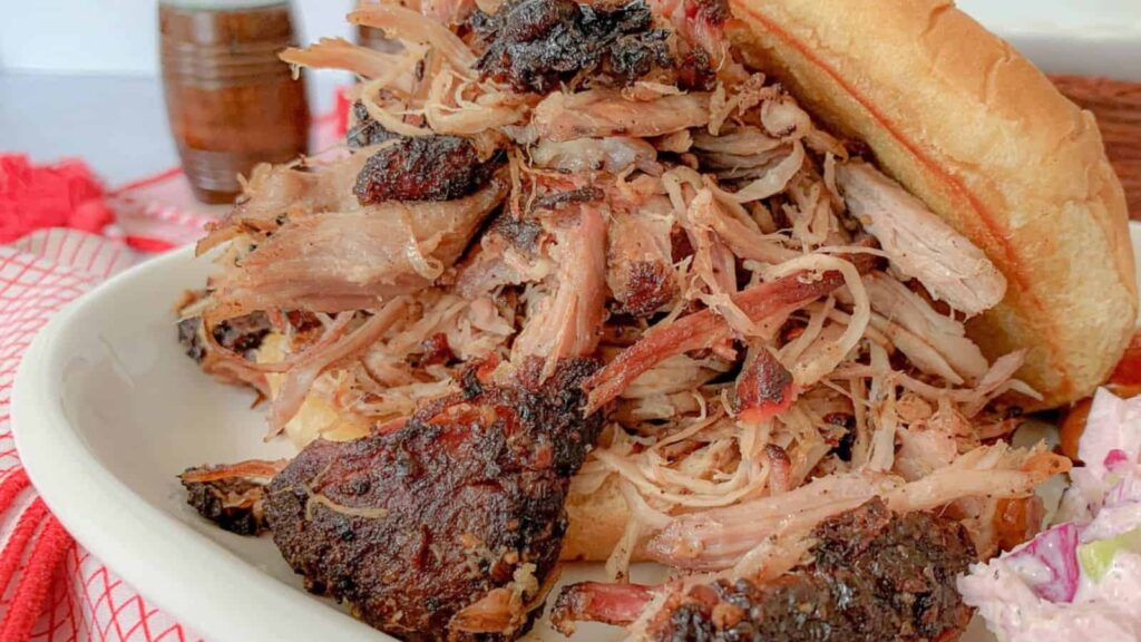 A Pulled Pork Sandwich open on a plate.