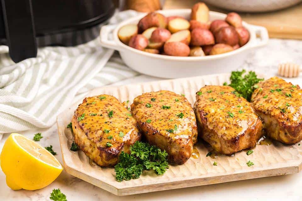 Air Fryer Honey Mustard Pork Chops on a wooden borad.