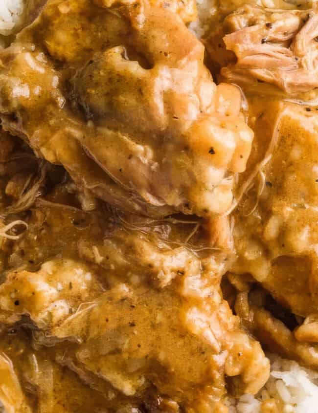 A bowl filled with white rice topped with pieces of chicken covered in creamy brown gravy. The dish appears to be a hearty, homestyle Southern recipe with tender, shredded chicken immersed in the rich, thick sauce, creating a savory and comforting presentation.