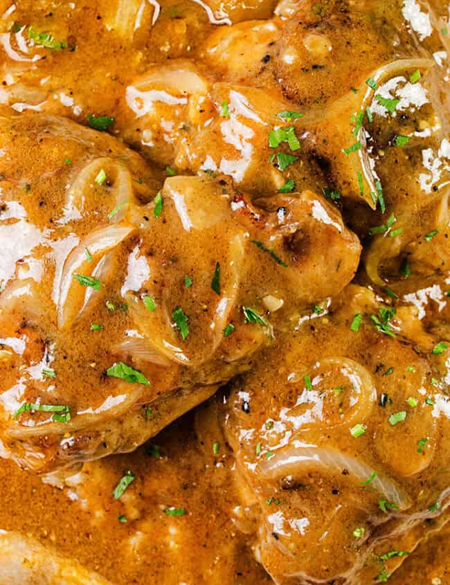 Close-up of a dish with tender pieces of meat simmered in a slow cooker, enveloped in a rich, thick curry sauce, and garnished with chopped cilantro. The deep orange-brown hue reflects a masterful blend of spices and flavors that only slow cooker recipes can achieve.