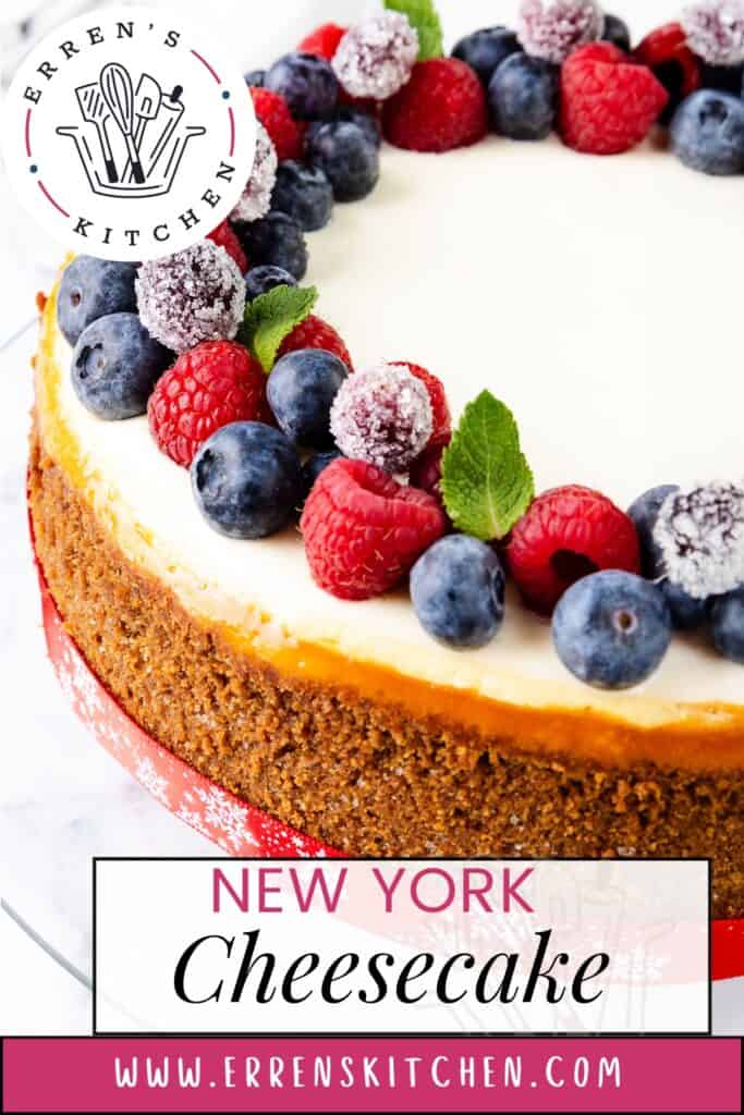 Indulge in a classic New York cheesecake adorned with fresh blueberries, raspberries, and sugared cranberries on a decorative cake board. Displayed on a pristine white surface alongside Erren's Kitchen logo and website, this dessert is a feast for both the eyes and the palate.