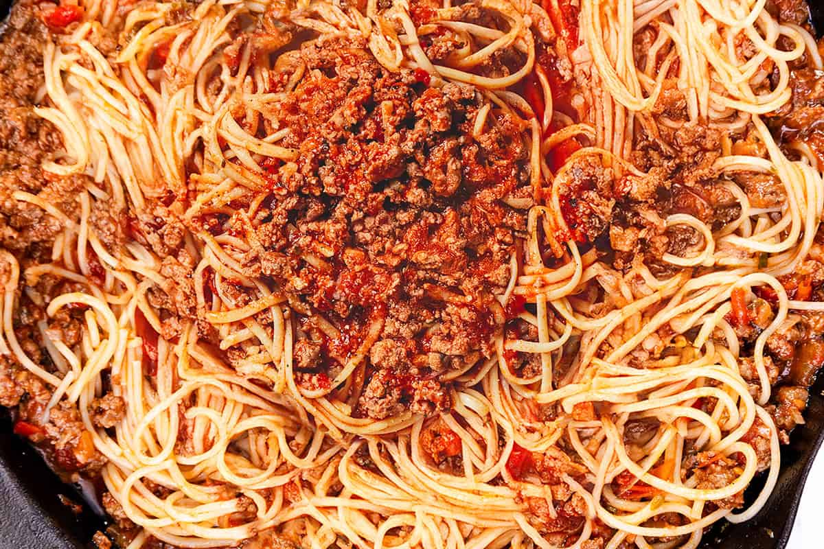 A close-up of spaghetti with a rich, savory meat sauce, featuring ground beef, tomatoes, and herbs. The pasta is evenly coated with the sauce, creating a hearty and appetizing classic dish.