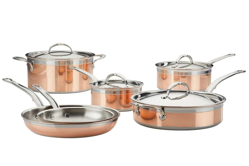 A set of shiny Hestan CopperBond Cookware, including pots with lids and frying pans, displayed on a white background. The collection features stainless steel handles and rims, emphasizing a stylish design perfect for a modern kitchen.