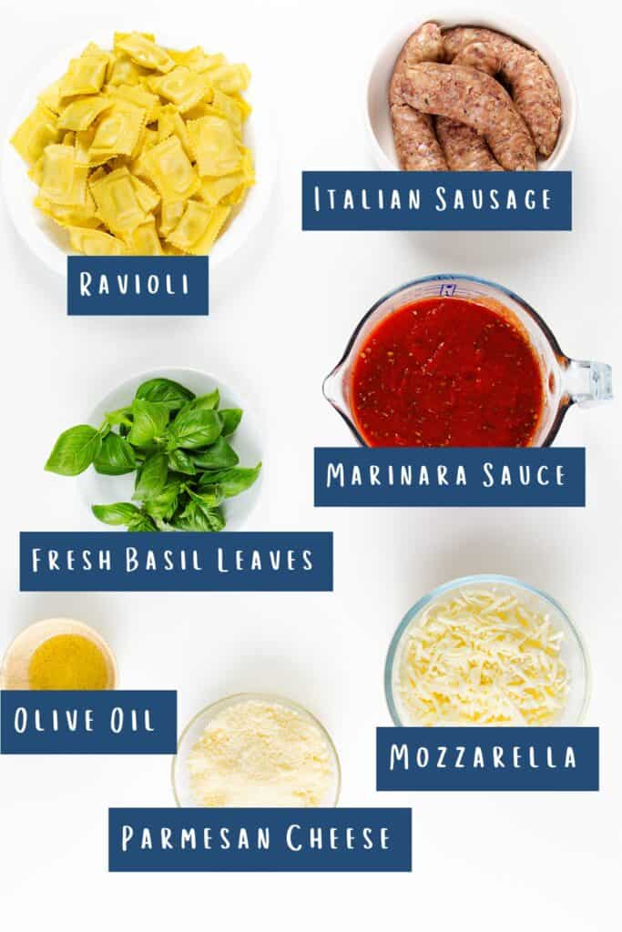 Image of ingredients for a delightful Italian casserole: ravioli, savory Italian sausage, marinara sauce, fresh basil leaves, olive oil, mozzarella, and Parmesan cheese, all beautifully labeled against a pristine white background.